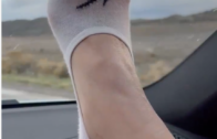 girl’s foot with ped socks over a car dashboard